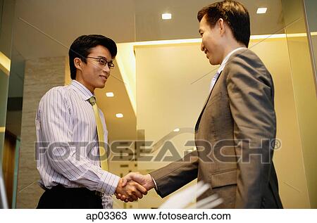 Stock Image - Businessmen shaking hands. Fotosearch