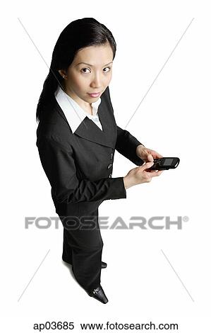 Businesswoman holding mobile phone, looking at camera View Large Photo Image Stock Photography - Businesswoman holding mobile phone, looking at camera . Fotosearch