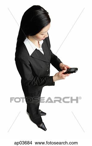 Businesswoman looking at mobile phone View Large Photo Image Picture - Businesswoman looking at mobile phone . Fotosearch