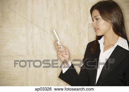 Businesswoman looking at mobile phone View Large Photo Image Stock Photograph - Businesswoman looking at mobile phone. Fotosearch