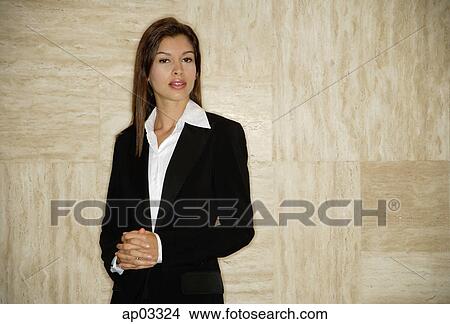 Businesswoman standing, hands clasped, looking at camera View Large Photo Image Picture - Businesswoman standing, hands clasped, looking at camera . Fotosearch