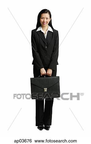 Businesswoman standing with briefcase, looking at camera View Large Photo Image Stock Photograph - Businesswoman standing with briefcase, looking at camera . Fotosearch