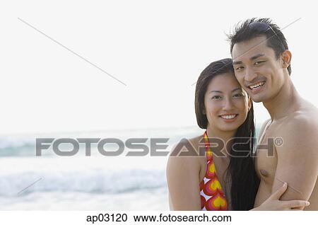Couple looking at camera, sea behind them View Large Photo Image Stock Image - Couple looking at camera, sea behind them. Fotosearch