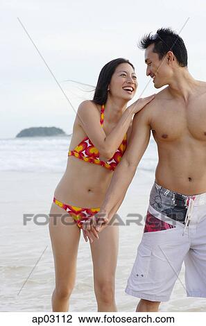 Couple on beach, holding hands, laughing View Large Photo Image Stock Image - Couple on beach, holding hands, laughing. Fotosearch