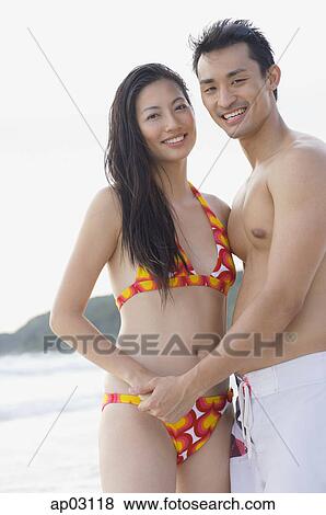 Couple on beach, holding hands, looking at camera View Large Photo Image Stock Photo - Couple on beach, holding hands, looking at camera . Fotosearch