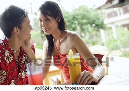 Couple sitting and smiling at each other View Large Photo Image Stock Photography - Couple sitting and smiling at each other . Fotosearch