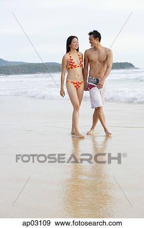Couple walking on beach, holding hands View Large Photo Image Stock Photo - Couple walking on beach, holding hands . Fotosearch