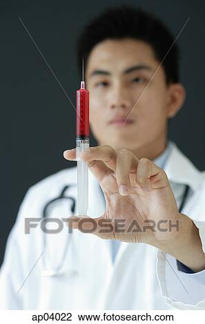 Doctor holding syringe View Large Photo Image Stock Image - Doctor holding syringe. Fotosearch