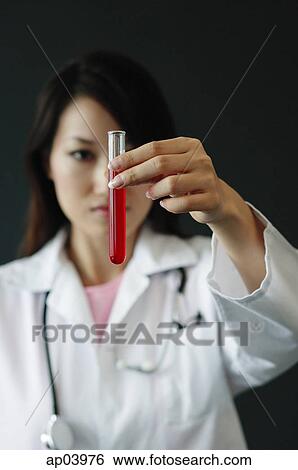 Doctor holding test tube filled with red liquid, selective focus View Large Photo Image Stock Photograph - Doctor holding test tube filled with red liquid, selective focus . Fotosearch