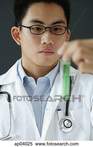Doctor holding test tube filled with green liquid View Large Photo Image Stock Photography - Doctor holding test tube filled with green liquid . Fotosearch