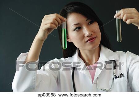Stock Photo - Doctor holding up two test tubes. Fotosearch