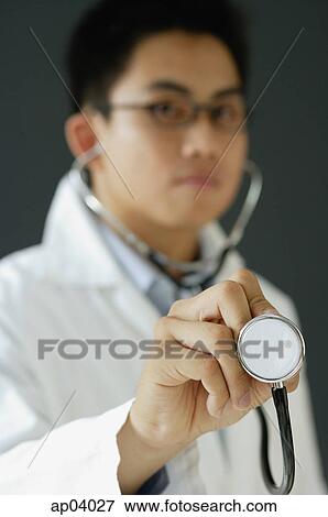 Doctor listening to stethoscope View Large Photo Image Stock Photo - Doctor listening to stethoscope . Fotosearch