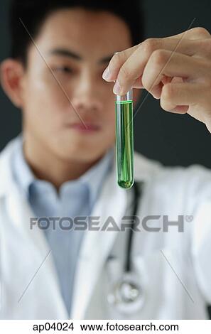 Picture - Doctor looking at test tube filled with green liquid . Fotosearch