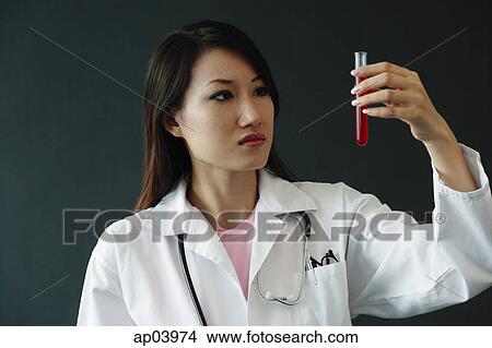 Doctor looking at test tube, serious expression View Large Photo Image Picture - Doctor looking at test tube, serious expression . Fotosearch