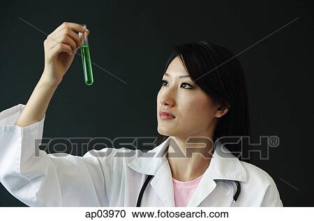 Stock Image - Doctor looking at test tube. Fotosearch