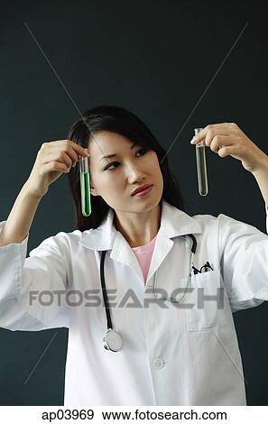 Doctor looking at two test tubes View Large Photo Image Stock Photo - Doctor looking at two test tubes . Fotosearch