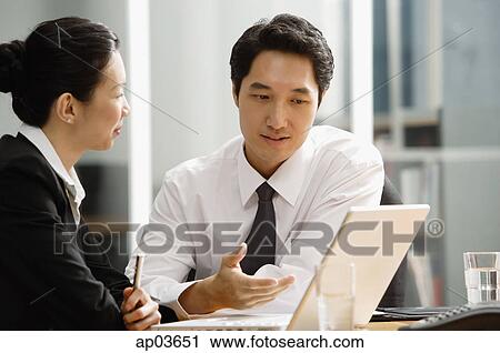 Executives having a discussion, looking at laptop View Large Photo Image Stock Image - Executives having a discussion, looking at laptop . Fotosearch