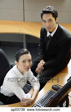Stock Photo - Executives in office cubicle, looking at camera. Fotosearch
