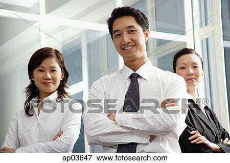 Executives standing with arms crossed, smiling at camera View Large Photo Image Stock Photo - Executives standing with arms crossed, smiling at camera . Fotosearch