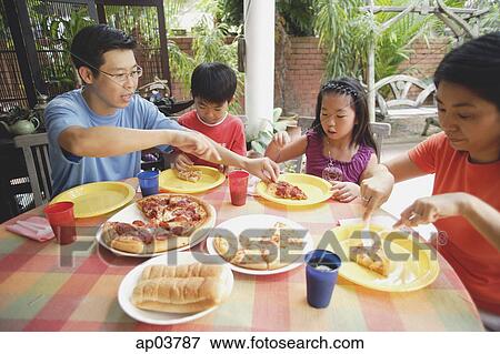 Family of four having pizza on patio View Large Photo Image Stock Photo - Family of four having pizza on patio. Fotosearch