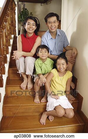 Family sitting on stairs, smiling at camera, portrait View Large Photo Image Stock Photo - Family sitting on stairs, smiling at camera, portrait. Fotosearch