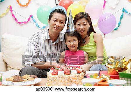 Stock Photo - Family with one child sitting with birthday cake, portrait . Fotosearch