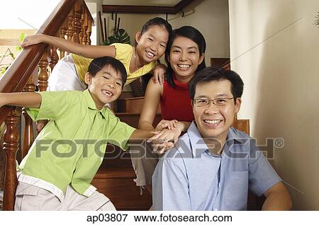 Family with two children, sitting on stairs, smiling at camera, portrait View Large Photo Image Stock Photo - Family with two children, sitting on stairs, smiling at camera, portrait . Fotosearch
