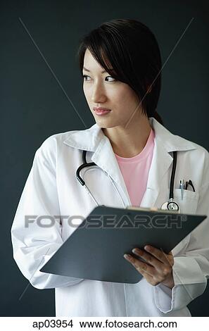 Female doctor, holding clipboard, looking away View Large Photo Image Picture - Female doctor, holding clipboard, looking away. Fotosearch