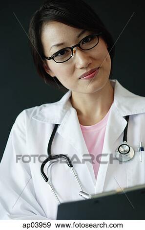 Female doctor holding clipboard, looking at camera View Large Photo Image Stock Photo - Female doctor holding clipboard, looking at camera. Fotosearch