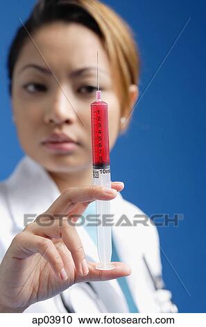 Female doctor looking at syringe View Large Photo Image Stock Image - Female doctor looking at syringe . Fotosearch