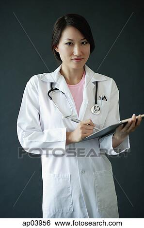 Female doctor standing with clipboard View Large Photo Image Stock Photograph - Female doctor standing with clipboard. Fotosearch