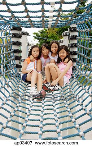 Four girls at playground, sitting in net tunnel View Large Photo Image Stock Photo - Four girls at playground, sitting in net tunnel . Fotosearch
