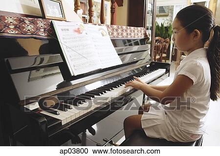Girl at home, playing piano View Large Photo Image Stock Image - Girl at home, playing piano. Fotosearch