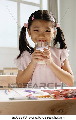 Stock Image - Girl holding glass of milk . Fotosearch