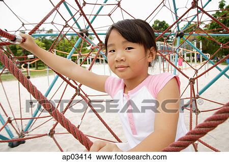 Picture - Girl on jungle gym, looking at camera . Fotosearch