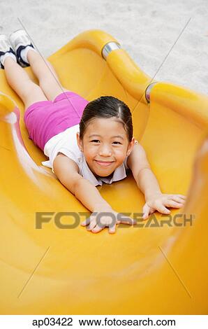 Girl on slide, smiling at camera View Large Photo Image Stock Image - Girl on slide, smiling at camera . Fotosearch