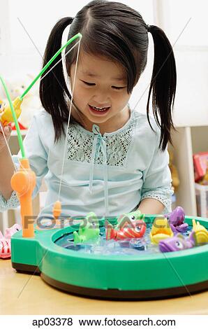 Girl playing with fishing game View Large Photo Image Stock Photo - Girl playing with fishing game. Fotosearch