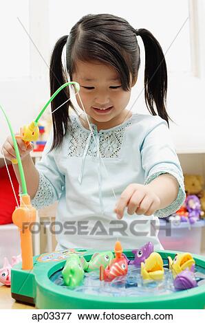 Stock Photo - Girl playing with fishing toy . Fotosearch