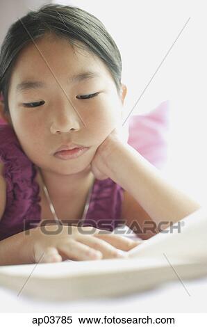 Stock Photography - Girl reading book, hand on chin. Fotosearch