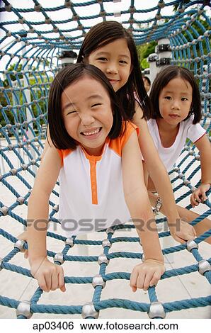 Girls at playground, crawling through net tunnel View Large Photo Image Stock Photograph - Girls at playground, crawling through net tunnel . Fotosearch
