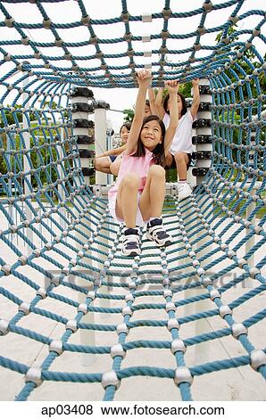 Girls going through net tunnel in playground View Large Photo Image Stock Photo - Girls going through net tunnel in playground . Fotosearch