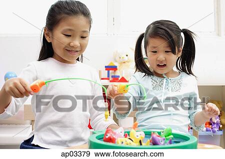 Girls playing with fishing game View Large Photo Image Stock Photo - Girls playing with fishing game . Fotosearch