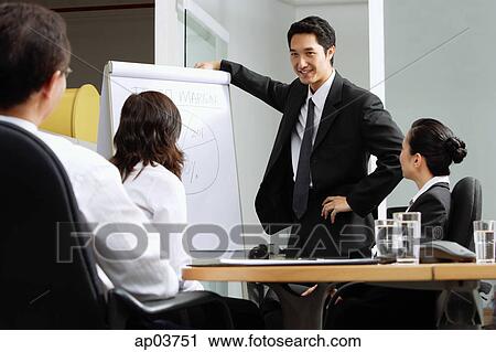 Group having a business meeting, man standing next to flipchart View Large Photo Image Stock Image - Group having a business meeting, man standing next to flipchart . Fotosearch