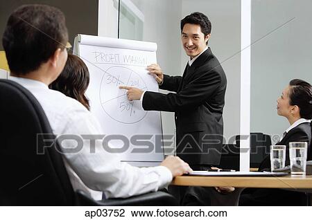 Group having a business meeting, man pointing at flipchart View Large Photo Image Stock Image - Group having a business meeting, man pointing at flipchart . Fotosearch