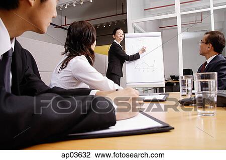 Group having a business meeting, woman writing on flipchart View Large Photo Image Stock Image - Group having a business meeting, woman writing on flipchart . Fotosearch