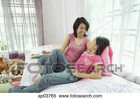 Mother and daughter in bedroom, side by side, looking at each other View Large Photo Image Stock Photography - Mother and daughter in bedroom, side by side, looking at each other. Fotosearch