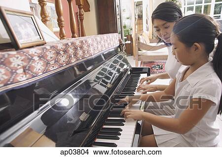 Mother and daughter playing the piano View Large Photo Image Picture - Mother and daughter playing the piano . Fotosearch