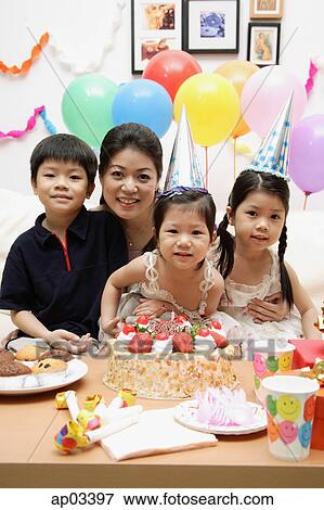 Stock Photo - Mother with three children celebrating a birthday . Fotosearch