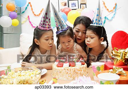 Mother with three girls celebrating a birthday, blowing candles on cake View Large Photo Image Stock Image - Mother with three girls celebrating a birthday, blowing candles on cake . Fotosearch