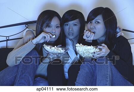 Three girls in bedroom, eating popcorn, watching TV View Large Photo Image Stock Image - Three girls in bedroom, eating popcorn, watching TV . Fotosearch